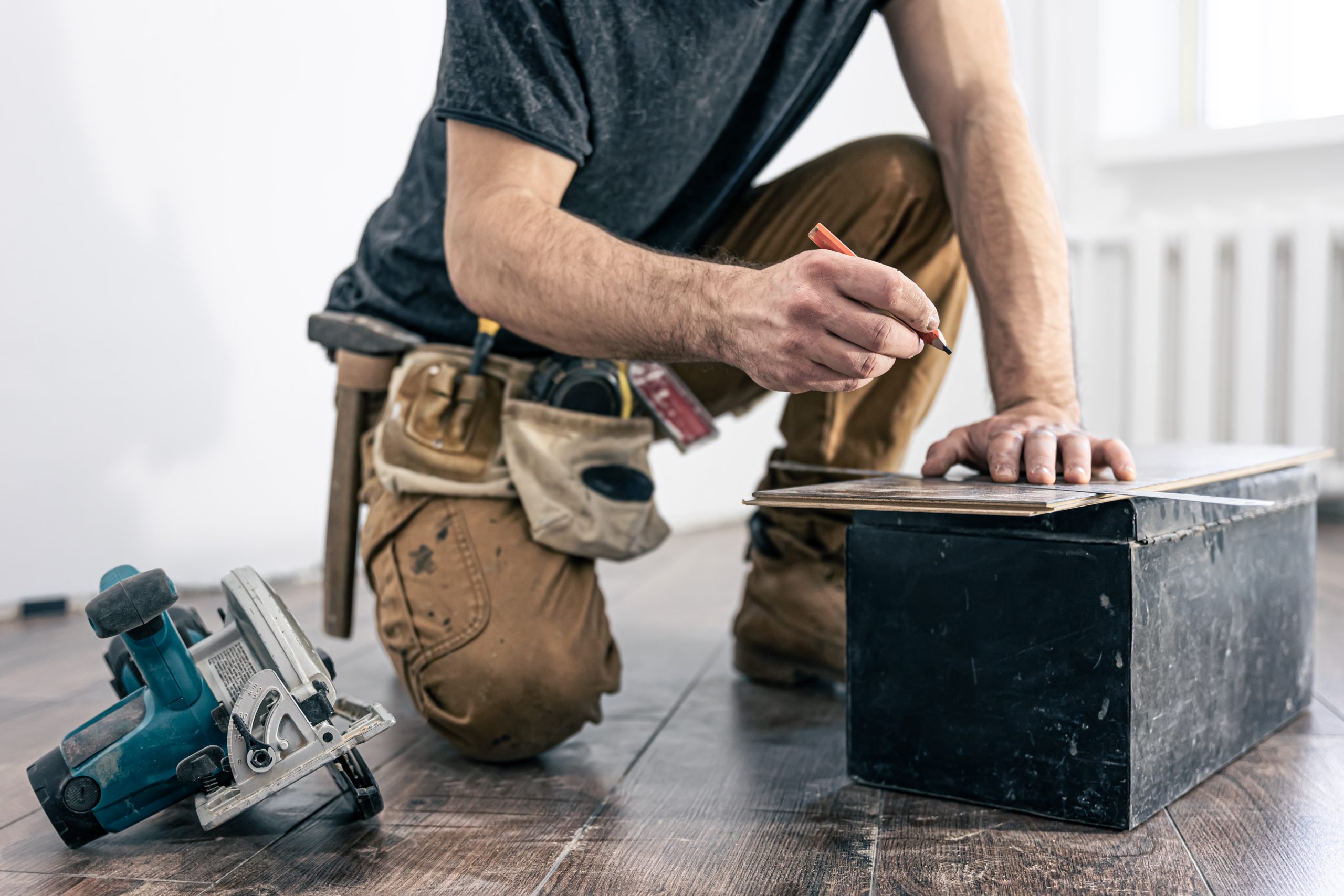 Skilled worker using saw on wood